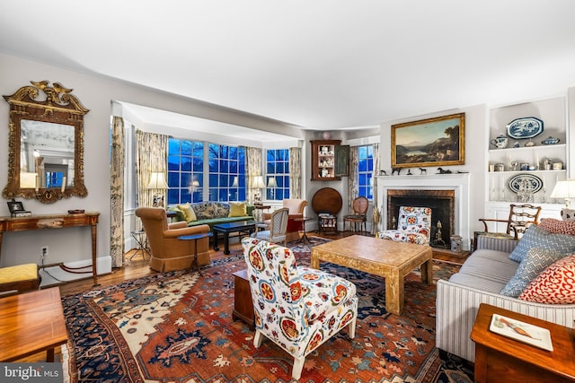 living room featuring wood finished floors and a fireplace with raised hearth