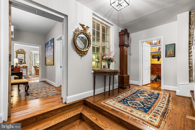 hallway with baseboards and wood finished floors