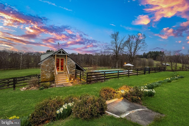 view of yard with a wooded view and fence