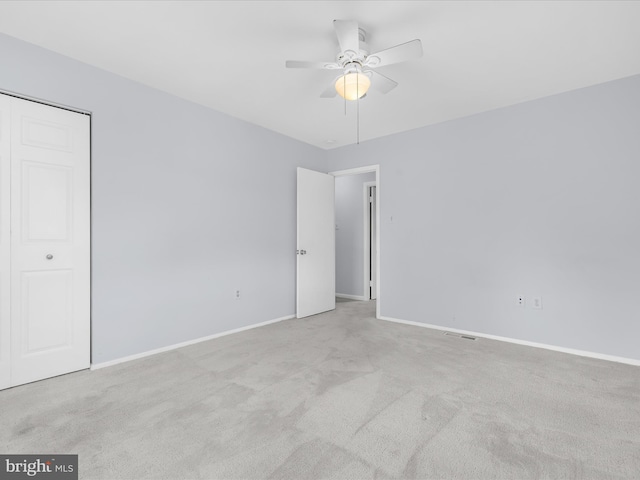 carpeted empty room with ceiling fan and baseboards