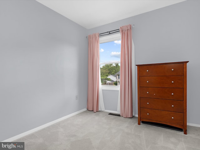 bedroom featuring light colored carpet and baseboards