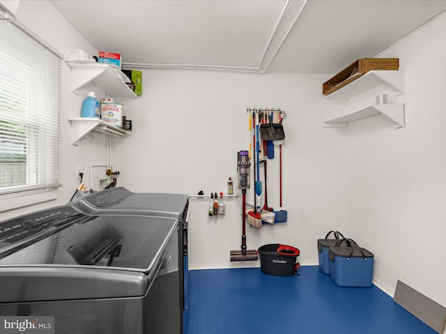 laundry room featuring washing machine and dryer and baseboards