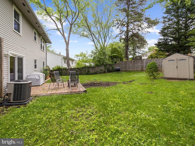 view of yard featuring cooling unit, a storage shed, and an outbuilding