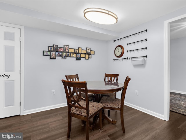 dining space featuring dark wood-style floors and baseboards