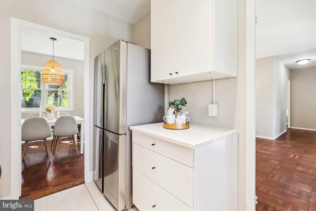 kitchen featuring decorative light fixtures, white cabinets, light countertops, and freestanding refrigerator
