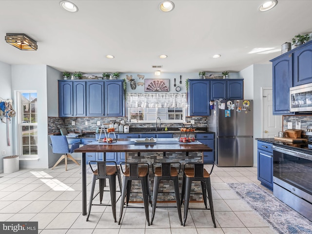 200 Rubens Cir, Martinsburg, WV 25403 - kitchen featuring dark countertops, blue cabinetry, backsplash, and stainless steel appliances