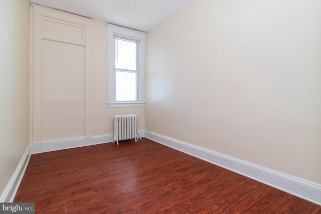 2607 Quantico Ave, Baltimore, MD 21215 - spare room featuring baseboards, radiator, and dark wood-style flooring