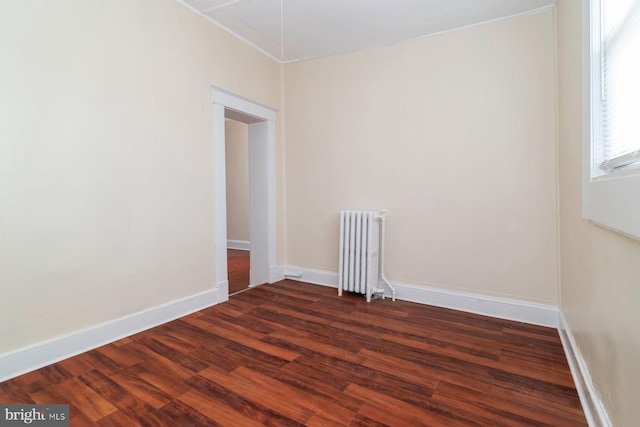 2607 Quantico Ave, Baltimore, MD 21215 - unfurnished room featuring crown molding, radiator heating unit, attic access, baseboards, and dark wood-style floors