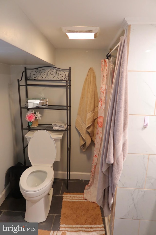 bathroom with tile patterned floors, baseboards, a shower with curtain, and toilet
