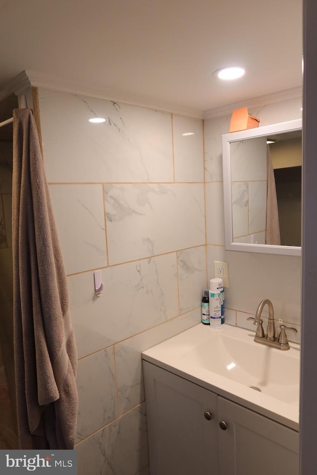 bathroom featuring vanity and tile walls