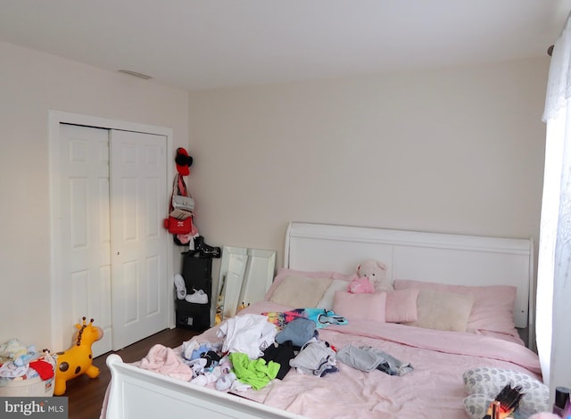 bedroom with a closet and dark wood finished floors