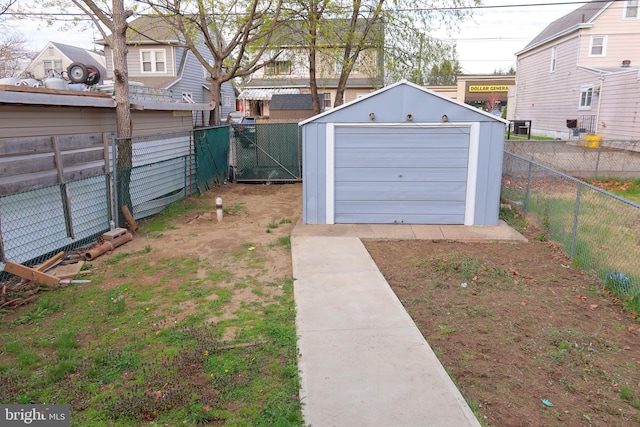 view of yard featuring an outbuilding, a fenced backyard, and a garage