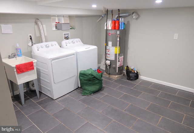 laundry area featuring baseboards, gas water heater, washing machine and dryer, and recessed lighting