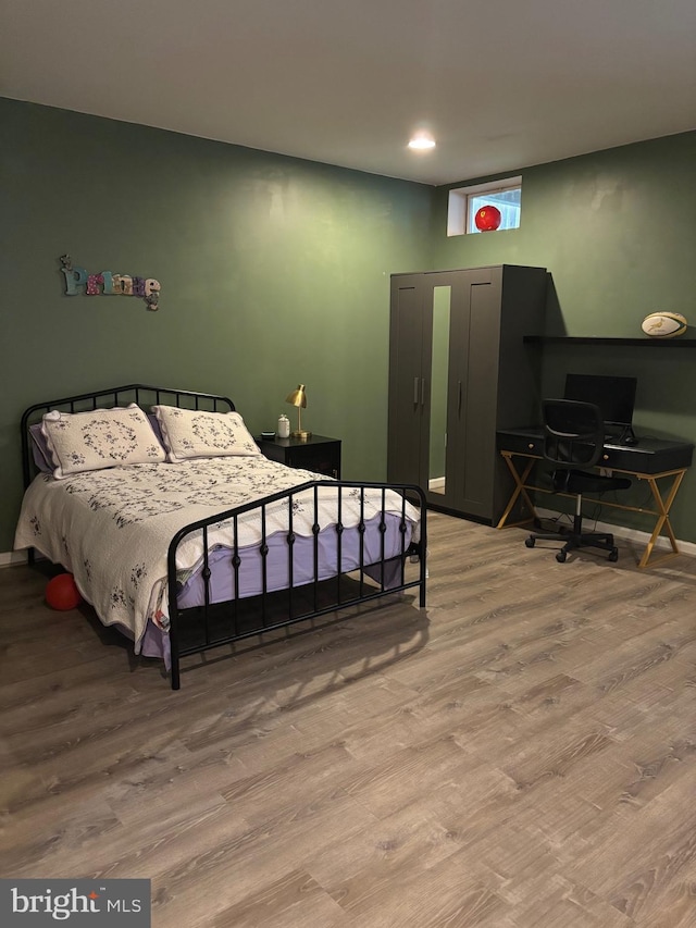 bedroom with light wood finished floors, baseboards, and recessed lighting