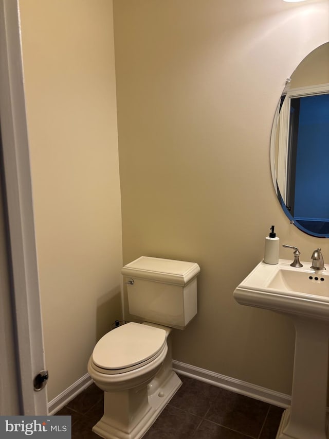 bathroom featuring toilet, tile patterned flooring, and baseboards