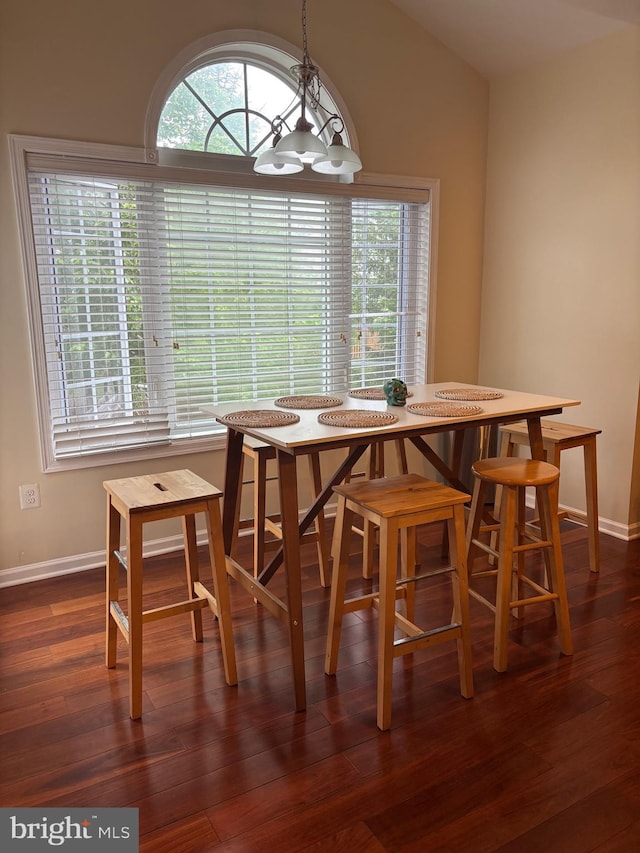 dining room featuring baseboards, a notable chandelier, breakfast area, and dark wood-style floors