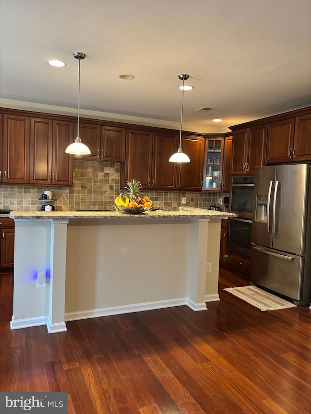 kitchen with glass insert cabinets, light stone counters, dark wood finished floors, decorative backsplash, and stainless steel appliances