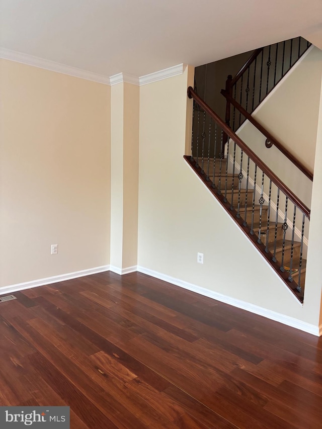 unfurnished living room with wood finished floors, visible vents, baseboards, ornamental molding, and stairs