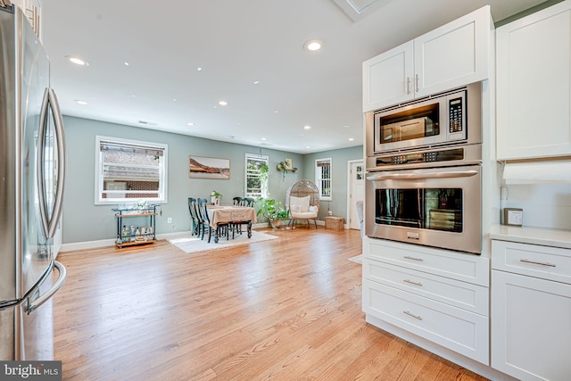 817 57th Pl, Fairmount Heights, MD 20743 - kitchen featuring appliances with stainless steel finishes, light wood-type flooring, white cabinets, open floor plan, and recessed lighting