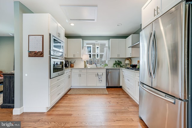 817 57th Pl, Fairmount Heights, MD 20743 - kitchen with light countertops, stainless steel appliances, light wood-style flooring, and white cabinetry