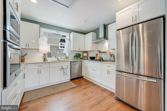817 57th Pl, Fairmount Heights, MD 20743 - kitchen featuring wall chimney range hood, appliances with stainless steel finishes, a sink, white cabinets, and recessed lighting