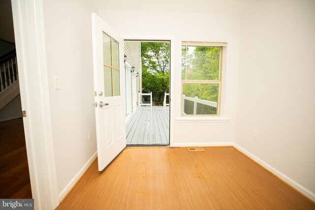 doorway to outside with light wood-style floors, baseboards, and visible vents
