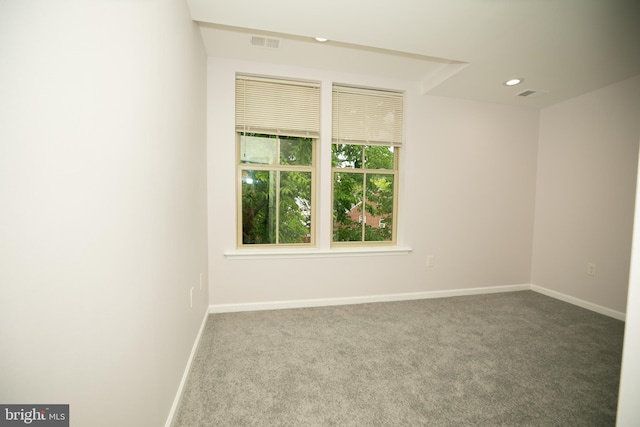 carpeted spare room featuring visible vents, baseboards, and recessed lighting