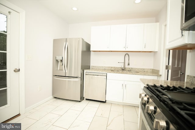 kitchen with white cabinets, a sink, appliances with stainless steel finishes, recessed lighting, and marble finish floor