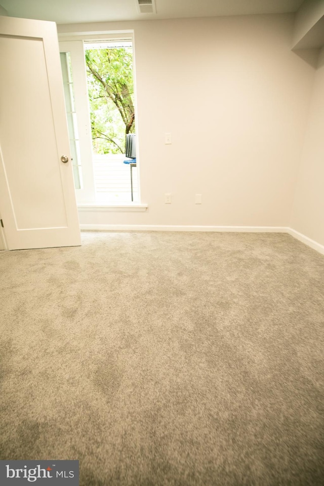 carpeted empty room with baseboards and visible vents