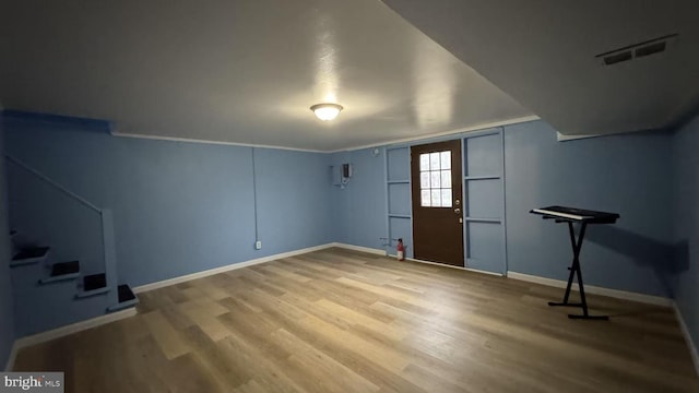foyer entrance featuring visible vents, baseboards, and wood finished floors