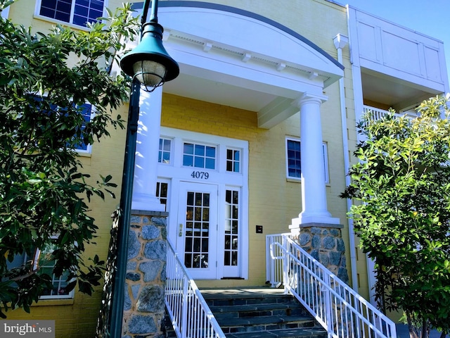 view of exterior entry with french doors and brick siding