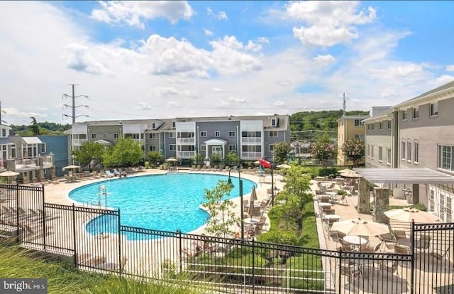 community pool with a patio and fence