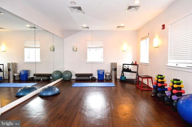 exercise area with visible vents and wood finished floors