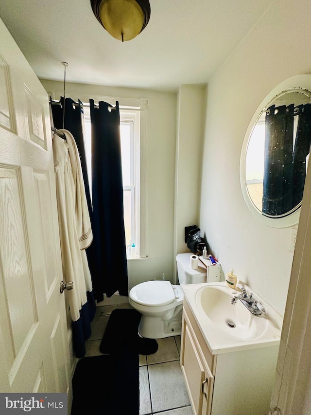 bathroom featuring toilet, a shower with shower curtain, tile patterned flooring, and vanity