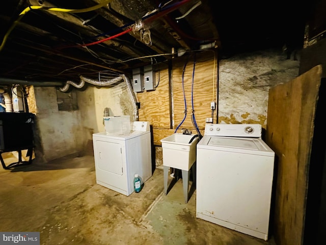laundry room with laundry area, separate washer and dryer, and a sink