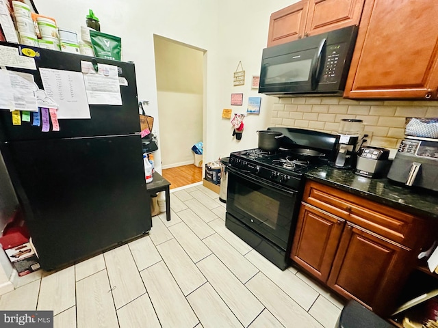 kitchen featuring brown cabinetry, tasteful backsplash, baseboards, and black appliances