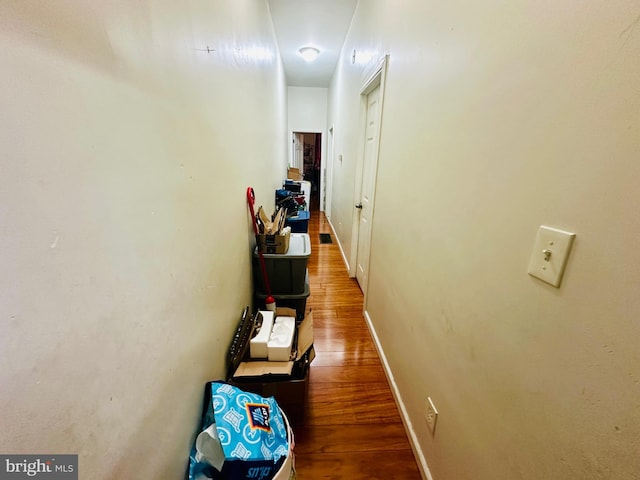 hallway featuring baseboards and wood finished floors