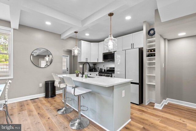 4033 Woodhaven Ave, Baltimore, MD 21216 - kitchen featuring appliances with stainless steel finishes, white cabinetry, beamed ceiling, light wood-style flooring, and a breakfast bar area
