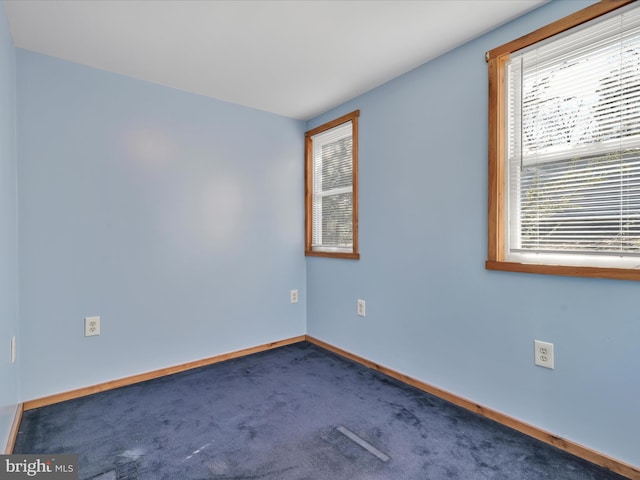 carpeted empty room featuring baseboards
