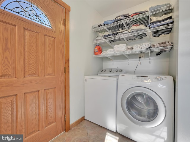 laundry area with baseboards, washer and clothes dryer, laundry area, and light tile patterned floors