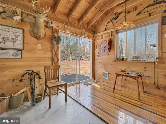 sitting room with hardwood / wood-style flooring, vaulted ceiling with beams, wooden walls, wooden ceiling, and visible vents