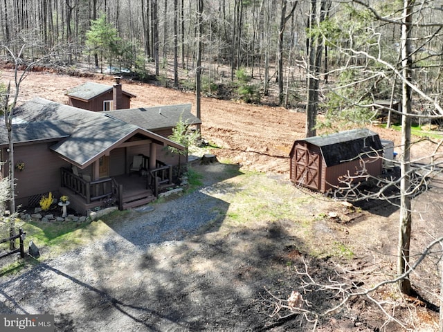 view of yard with a porch, an outbuilding, and a shed