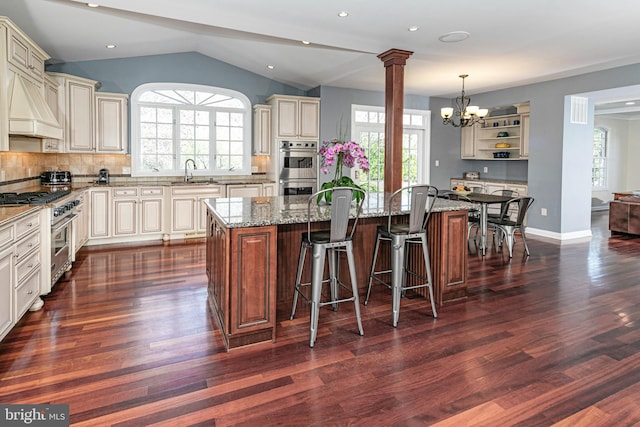 kitchen featuring a sink, premium range hood, a chandelier, cream cabinetry, and stainless steel appliances