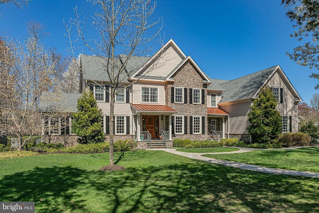 view of front of home with a front yard and stone siding