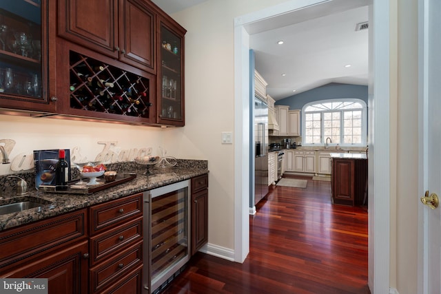 bar featuring dark wood-type flooring, a sink, lofted ceiling, and wine cooler