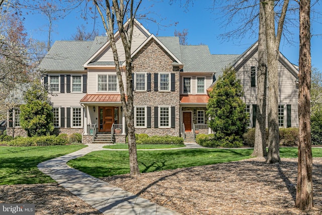 view of front facade with stone siding and a front lawn