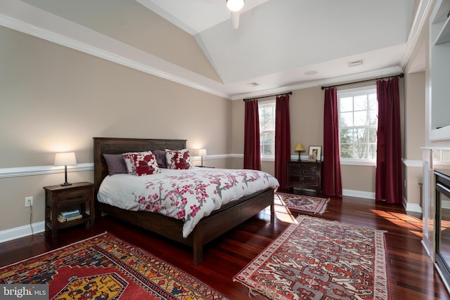 bedroom with a fireplace with flush hearth, wood finished floors, baseboards, and lofted ceiling