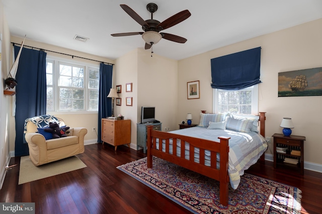 bedroom featuring visible vents, multiple windows, and wood finished floors