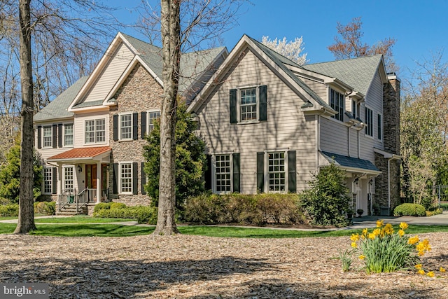 view of front of house with a chimney and stone siding