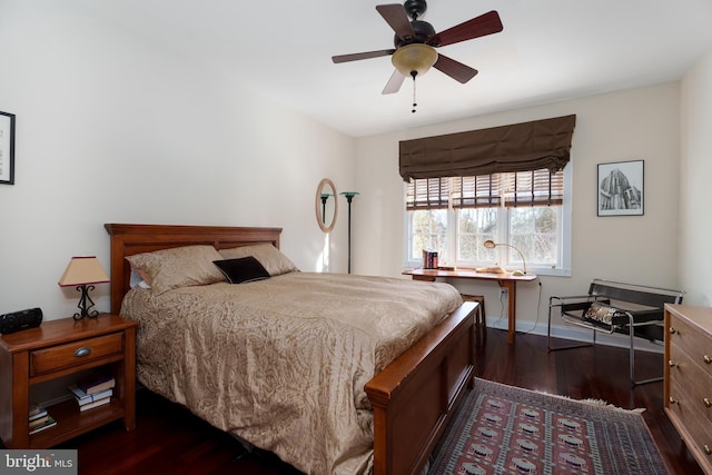 bedroom with ceiling fan, dark wood-style flooring, and baseboards